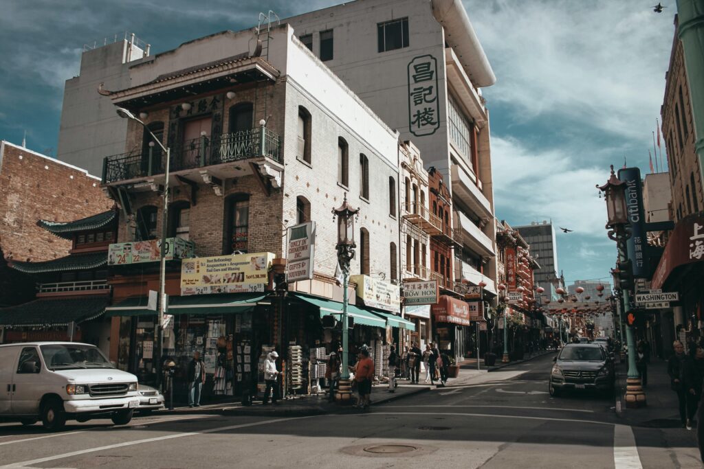 A vibrant street scene in San Francisco's Chinatown with shops, people, and historic architecture.